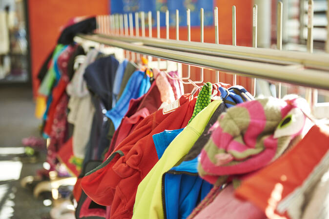 Eine Garderobe mit bunten Kinderjacken.